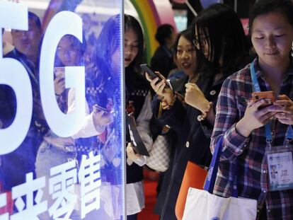 Unos usuarios utilizan sus dispositivos en la feria Internacional de Importaciones de China este mes. 