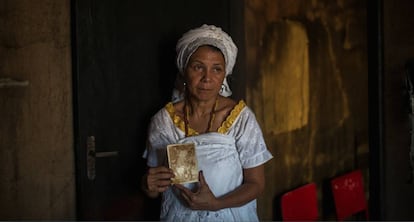 Mãe Merinha segura uma das fotos que sobrou do incêndio