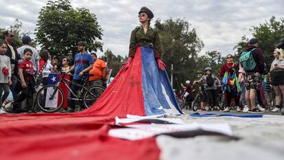 Una mujer, vestida de militar y envuelta en la bandera de Chile, en las protestas del pasado domingo 27 de octubre en Santiago.
