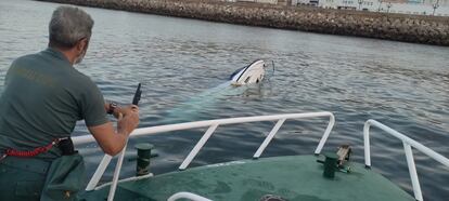 Un guardia civil actúa en la zona de la embarcación cargada de droga hundida, cerca del Campo del Sur en Cádiz.