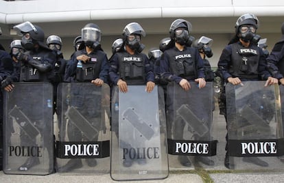 Policías antidisturbios tailandeses montan guardia ante un estadio deportivo en Bangkok de donde fueron evacuados varios funcionarios electorales.