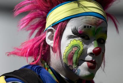 Un payaso con sus mejillas pintadas con la imagen de la Virgen en procesión hacia la Basílica de nuestra Señora de Guadalupe, en la Ciudad de México.