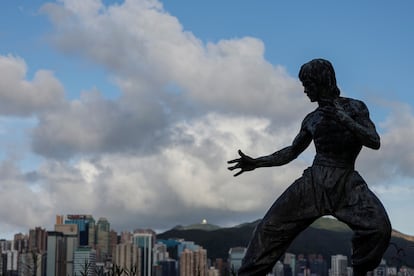 A statue of the martial artist and actor Bruce Lee is silhouetted against the skyline on the Avenue of Stars attraction near the Tsim Sha Tsui waterfront, in Hong Kong, China June 28, 2023.