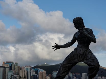 A statue of the martial artist and actor Bruce Lee is silhouetted against the skyline on the Avenue of Stars attraction near the Tsim Sha Tsui waterfront, in Hong Kong, China June 28, 2023.