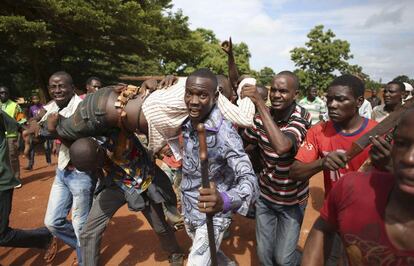 Manifestantes llevan a un hombre herido por disparos de bala de los soldados franceses. Los manifestantes bloqueaban una carretera en Bambari (República Centroafricana).