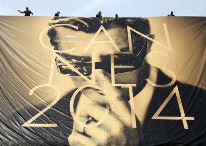 Varios empleados cuelgan el lunes un póster de la 67ª edición del Festival de Cannes en la fachada del Palais de Festivals, en Cannes.