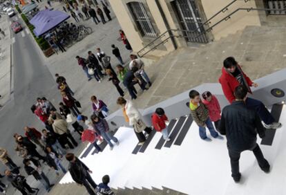 Varias personas comprueban el funcionamiento del teclado en las escalinatas de San Miguel, en Vitoria.