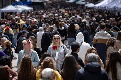 Centenares de personas caminan por la rambla de Cataluña en la Diada de Sant Jordi.