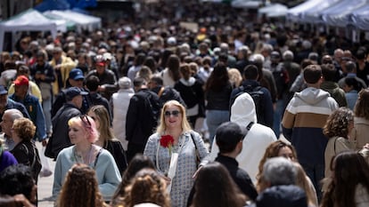 Centenares de personas caminan por la rambla de Cataluña en la Diada de Sant Jordi.