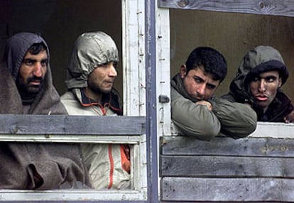 Varios inmigrantes kurdos se asoman a una ventana del campo de Sangatt, Francia.
