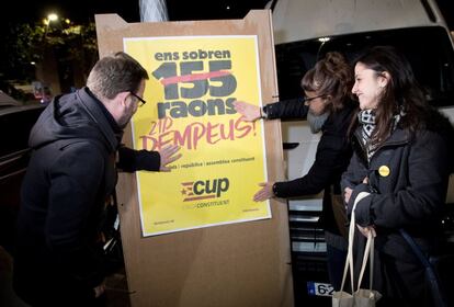 La número dos de la llista de la CUP per Barcelona, Maria Sirvent (d), el número tres, Vidal Aragonés i la regidora Maria Rovira enganxen cartells durant l'inici de campanya de la CUP.