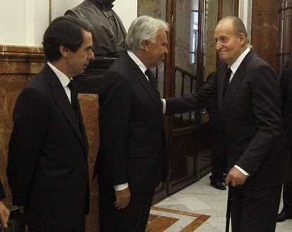 El Rey saluda al expresidente del Gobierno, Felipe González, en presencia del también expresidente José María Aznar a su llegada a la capilla ardiente de Adolfo Suárez, instalada en el Congreso.