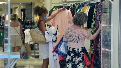 Gente comprando en ropa en una tienda.