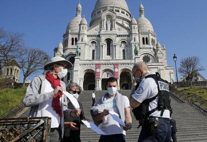 Un policía francés revisa los permisos de un grupo de personas en el barrio de Montmartre