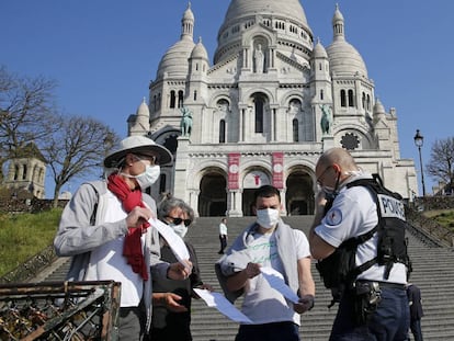 Un policía francés revisa los permisos de un grupo de personas en el barrio de Montmartre