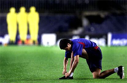 Riquelme se ata una bota durante un entrenamiento.