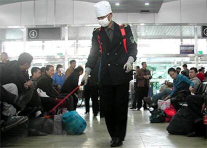 Un empleado sanitario desinfecta la sala de espera de una estación de autobuses en Harbin, en la provincia china de Heilongjiang.