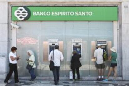 Un grupo de personas retira dinero de una sucursal del Banco Espirito Santo en Lisboa.