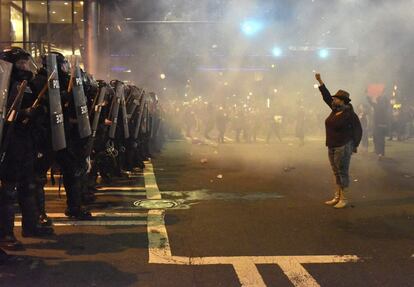 Manifestantes se encaran a policías antidisturbios con los brazos en alto durante unos disturbios en Charlotte en Carolina del Norte (Estados Unidos).
