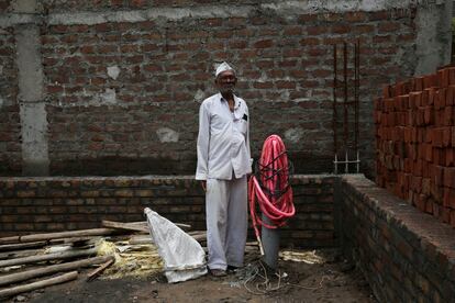 Un hombre, junto a un pozo en una obra en construcción, en India.