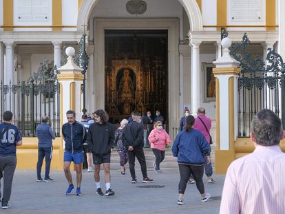 Fieles en la puerta de la basílica de La Macarena, en Sevilla.