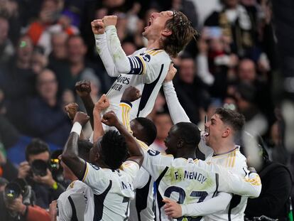 Modric celebra su gol al Sevilla sobre la valla del fondo norte del Bernabéu.