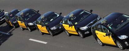 Taxis on strike drive in a procession during a strike against what they say is unfair competition from ride-hailing and car-sharing services such as Uber and Cabify in Barcelona