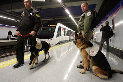 Dos guardias de seguridad, con los perros de la unidad de vigilancia canina del metro de Madrid.
