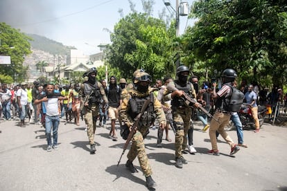 La policía conduce detenidos a dos extranjeros hoy, en Puerto Principe (Haití). Los dos fueron capturados por un grupo de personas al creer que están implicados en el asesinato del presidente de Haití, Jovenel Moise. Las autoridades han afirmado que Moise fue asesinado por mercenarios extranjeros.