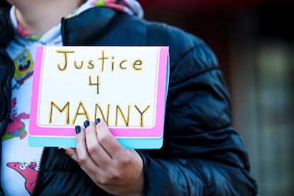 A protester holds a sign during a rally after the verdict was read during the trial of three Tacoma Police officers in the death of Manny Ellis, at Pierce County Superior Court, Thursday, Dec. 21, 2023, in Tacoma, Wash.