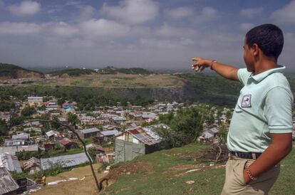 Wilson, de 16 años, señala la montaña de basura donde trabajaba a diario antes de comenzar en la escuela.