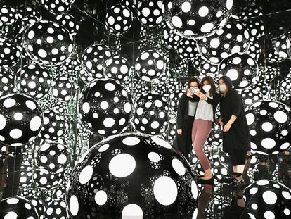 Young women take a selfie at a Yayoi Kusama