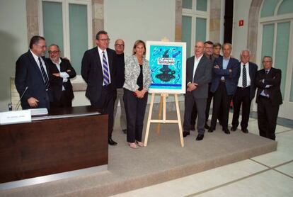 El fotógrafo Jordi Cotrina junto a la presidenta del Parlament, Nuria de Gispert, junto al premio, un cuadro de Pere Viladecans.