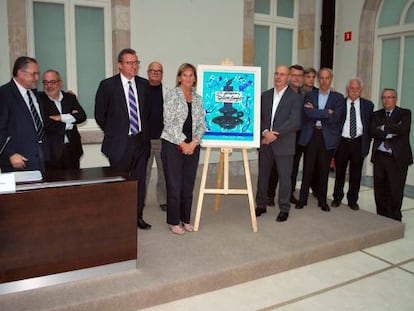 El fotógrafo Jordi Cotrina junto a la presidenta del Parlament, Nuria de Gispert, junto al premio, un cuadro de Pere Viladecans.