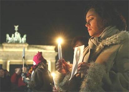 Carmen Martín, una mujer española, sostenía ayer una vela frente a la Puerta de Brandenburgo en Berlín.