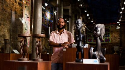 Igor Tiago, gestor cultura da Casa do Benin, no Pelourinho, em Salvador, posa em meio ao acervo do local.