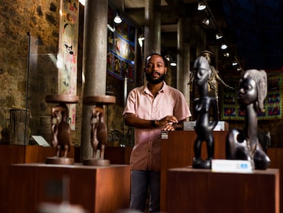 Igor Tiago, gestor cultura da Casa do Benin, no Pelourinho, em Salvador, posa em meio ao acervo do local.