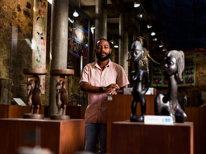 Igor Tiago, gestor cultura da Casa do Benin, no Pelourinho, em Salvador, posa em meio ao acervo do local.