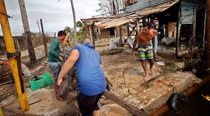 Damnificados recogen escombros tras el paso del huracán Rafael, en Playa Majana, en la provincia de Artemisa.