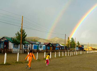 Dos niñas corretean en un poblado del centro de Mongolia tras una tormenta de verano.