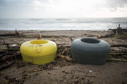 Dos cubells d'escombraries coberts de sorra a la platja de la Barceloneta després del fort temporal.