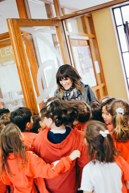 Los niños del colegio Santo Ángel de la Guarda abrazan a la antigua alumna. 