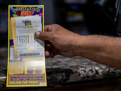 Un cliente muestra su billete de lotería comprado en una gasolinera CITGO el 10 de enero de 2023 en Austin, Texas.