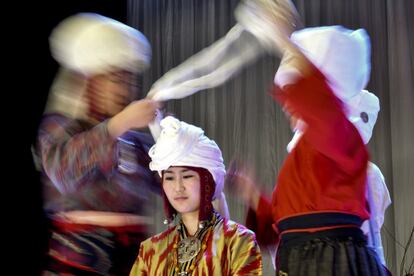 Una modelo es vestida en un elechek, un tocado tradicional de kirguiso, durante el festival nacional del traje en Biskek, Kirguistán.