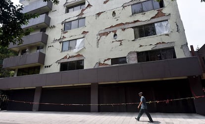 Un hombre pasa por delante de un edificio dañado en la Condesa.