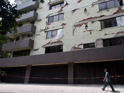 Un hombre pasa por delante de un edificio dañado en la Condesa.
