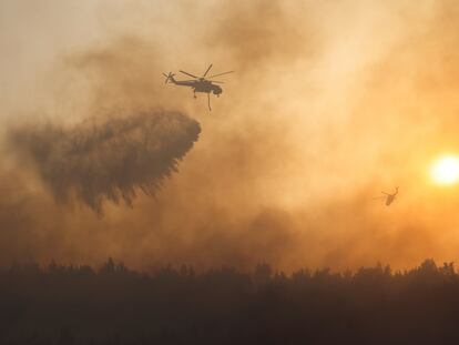 Um helicóptero joga água sobre o incêndio na região de Varimpompi, ao norte de Atenas.