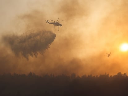 Un helicóptero vierte agua sobre el incendio en la zona de Varimpompi, al norte de Atenas.