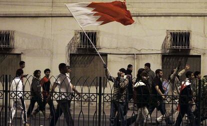 Manifestantes antigubernamentales ondean una bandera de Bahrein en las cercanías de la Plaza de la Perla.