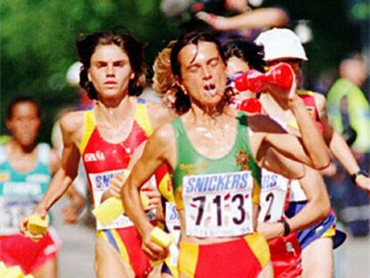 Varias corredoras de maratón recogen agua durante una carrera.